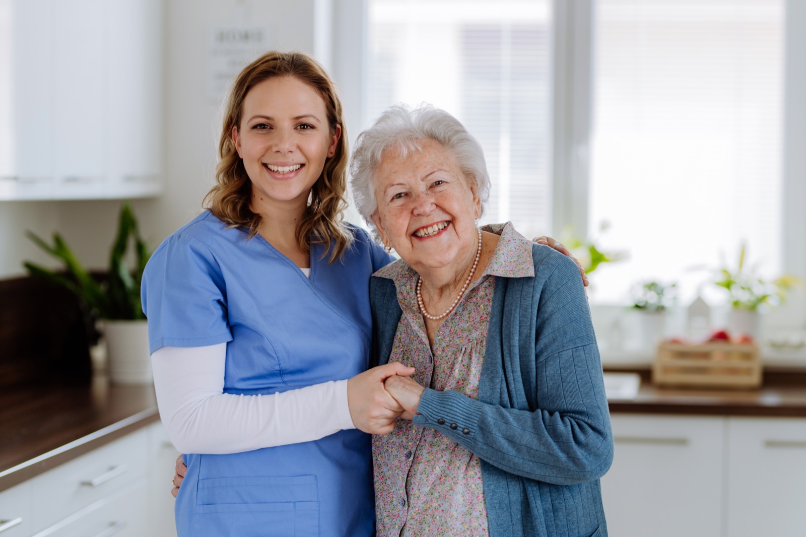 Seniorin lacht gemeinsam mit ihrer Alltagshelferin